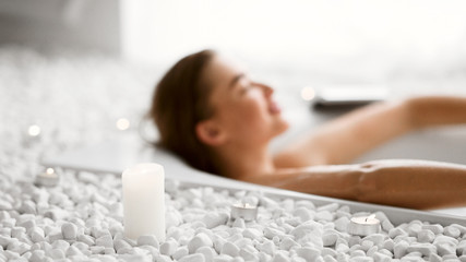 Young Woman Relaxing In Bath With Candles