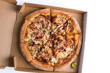 A whole sliced meat barbeque pizza in the delivery box.