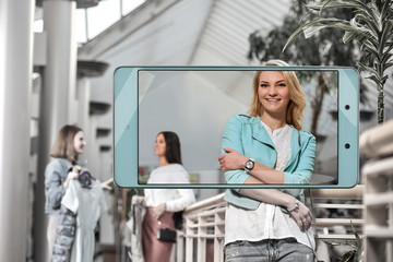 Obraz premium Portrait of beautiful smiling blonde on shopping, concept of new features in smartphone s camera