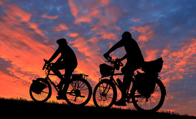 Obraz premium Silhouette group friend and bike relaxing on blurry sunset background.