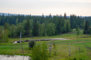Small ponds with water among the fields and roads in the Yakut taiga of the North.