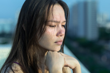 Sad woman depressed on her balcony.