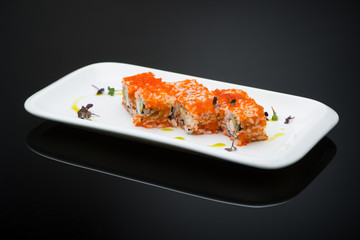 sushi in a plate on a black background with reflection. fish roll
