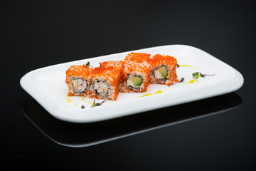 sushi in a plate on a black background with reflection. fish roll