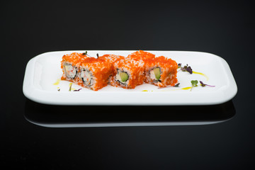 sushi in a plate on a black background with reflection. fish roll