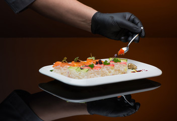 chef decorates sushi with caviar. process of cooking sushi