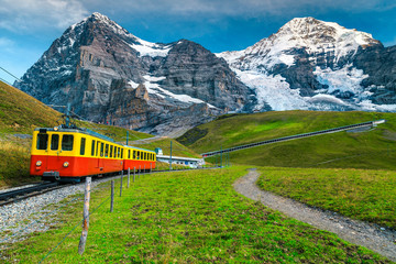 Fototapeta na wymiar Electric tourist train and snowy Eiger mountain, Bernese Oberland, Switzerland