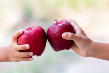 Childs is holding red Apples enjoy eat with blurred background, Healthy food for childs concept image