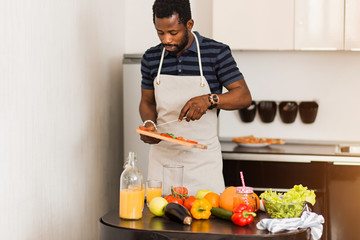 African man preparing healthy food at home in kitchen
