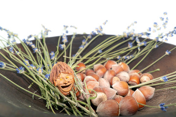 The smiling little man, object of artisanal art, talisman graven from peach pit on a dark wooden...
