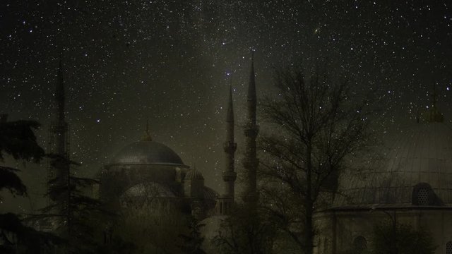Night in Istanbul. Blue mosque under a starry sky with a full moon and moon reflections on the roofs of buildings. Sultan Ahmed Mosque. Animation of making. Elements of this image furnished by NASA.