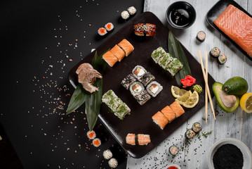 Sushi set with salmon, eel, tuna, avocado, cream cheese Philadelphia, caviar, chuka. Sushi menu. Japanese food on black and white background