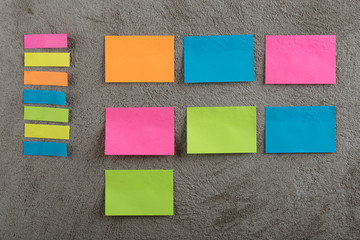 Many colorful sticky note on grey cement background. Copy space