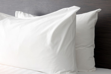 White pillows on comfortable bed in modern bedroom.