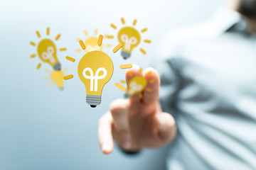  holding illuminated light bulb, idea, innovation and inspiration concept.