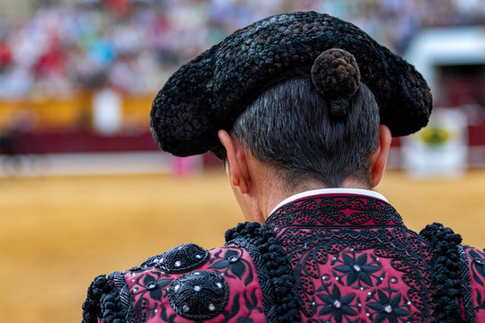 Torero de espaldas vestido de luces con la montera durante la corrida