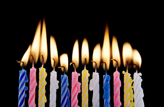 Burning birthday candles on black background