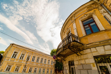 corner of a two-story house with a balcony. The old facade is yellow. low angle view © Konstantin