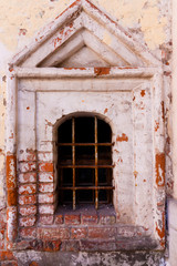 Fototapeta premium old destructed window surround made of bricks. instead of a window there is a lattice