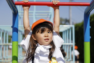 雲梯で遊ぶ制服を着た幼児 (4歳児)