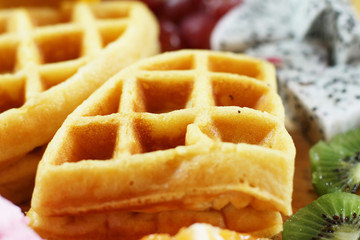 waffles with fruit and ice cream on wood plate