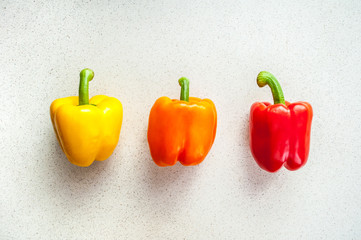 Colorful sweet peppers on a white kitchen table. Top view.