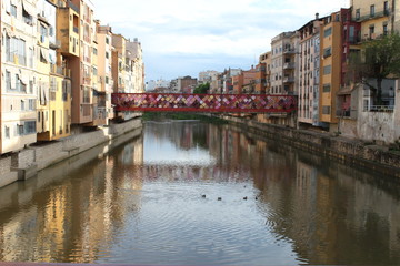 Fototapeta na wymiar Bridge over the Onyar river in Girona with colorful houses on each side