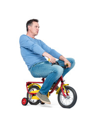 Fototapeta na wymiar Happy man in jeans and t-shirt on a children's bike, isolated on white background.