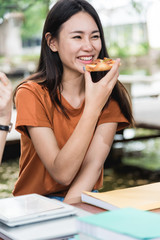 Portrait asian woman students eating pizza with cheese delicious