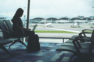 A woman traveler using laptop computer while sitting in the airport