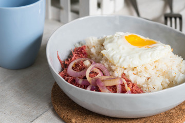delicious morning breakfast corned beef with egg on top of rice