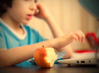 Obraz na płótnie Canvas bitten apple and a boy with computer