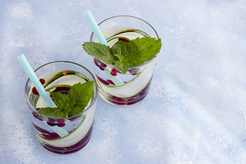Fresh cool detox drink with cucumber and berries, lemonade in a glass