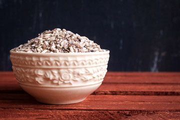 Raw organic sticky rice in white ceramic bowl.