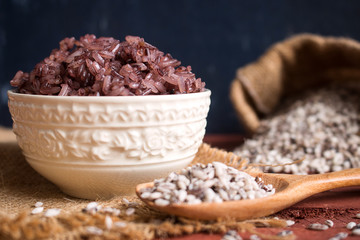Organic sticky rice in ceramic bowl on rustic wood