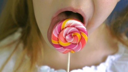 Little girl with a lollipop on a blue background. Close up portrait - Powered by Adobe