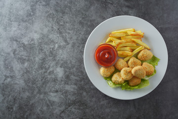 Chicken nuggets with french fried potatoes and ketchup, top view. Fast food.