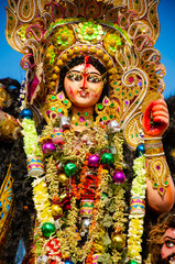 Golden and colorful statue of ten handed goddess Durga being worshiped with flower on the occasion...