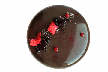 Dark glazed chocolate cake with berries on white background