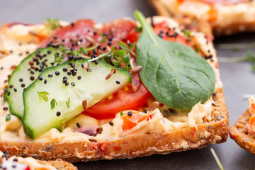 Sandwiches with cream cheese, vegetables and salami.