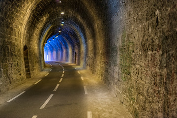 Fototapeta na wymiar Dark empty tunnel with curved road.