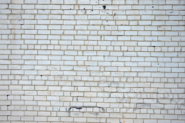 The texture of the facade of the building of white, damaged brick. Wide white wall background