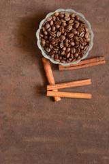 Coffee beans with fragrant cinnamon on rusty, scratched metal