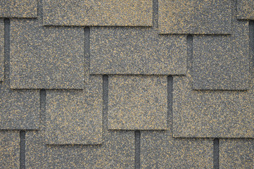 The texture of the rubberized asphalt crumb on the treadmill. The roof of the building is covered with concrete and resin. Background small pieces of brick