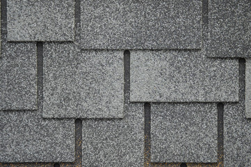The texture of the rubberized asphalt crumb on the treadmill. The roof of the building is covered with concrete and resin. Background small pieces of brick