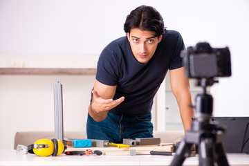 Young male repairman recording video for his blog 