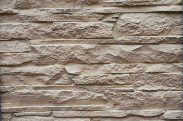 Natural stonework background of an old building. Damaged stones on the facade of the house