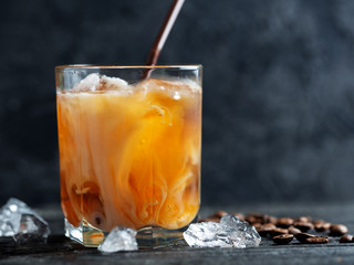 Iced coffee on a wooden table in a glass with copyspace