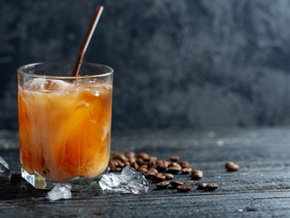 Iced coffee on a wooden table in a glass with copyspace