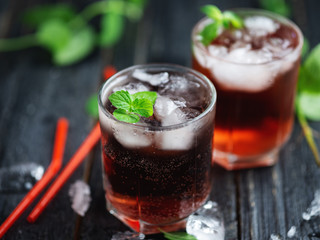 Two glasses of red cocktail with ice and mint close-up